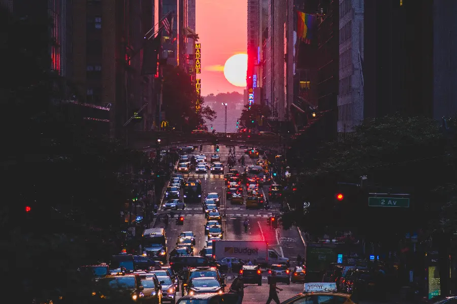 A noisy and bright image of a city road and the movement of cars on it at sunset