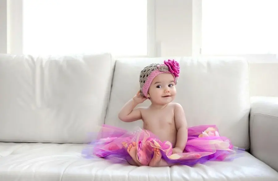 Lovely view of a naughty baby girl in a pink fluffy dress