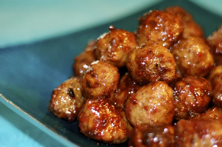 High quality background of exceptional meatballs dipped in tomato paste on a blue slanted plate suitable for WhatsApp