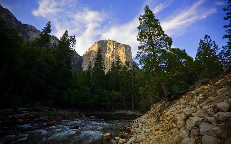 Incredible spring images of tree-filled and rocky nature with a high rocky mountain in low light