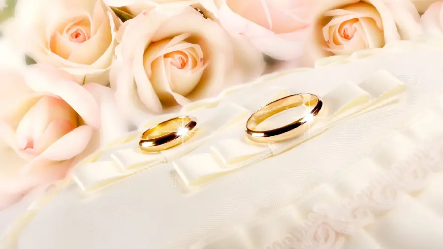 Sparkling background photo of 2 simple rings of bride and groom next to a bouquet of roses suitable for phone