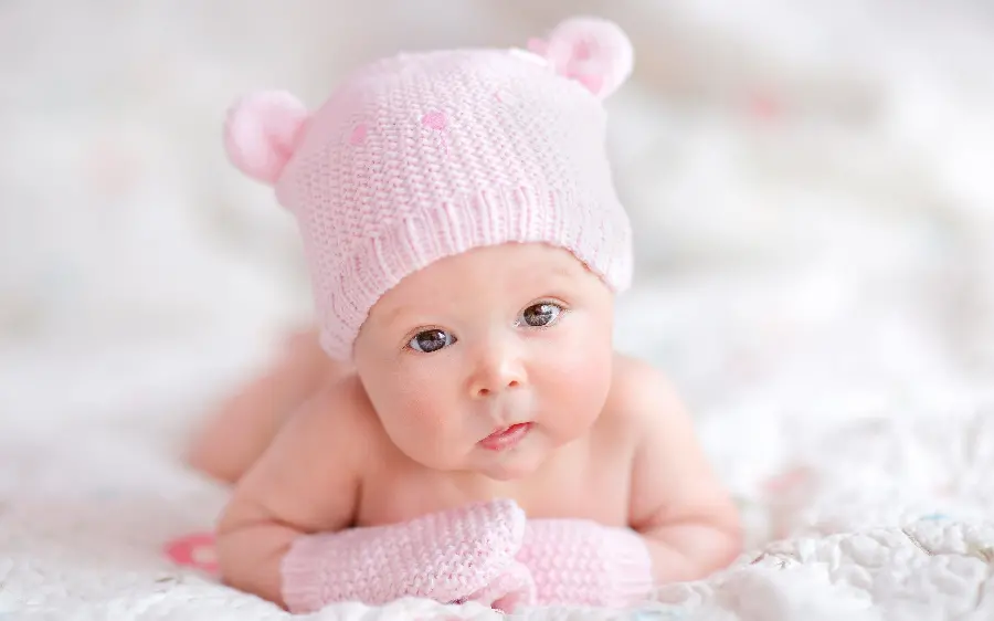 The cutest photo of a little baby girl with a pink fancy hat in an ideal view