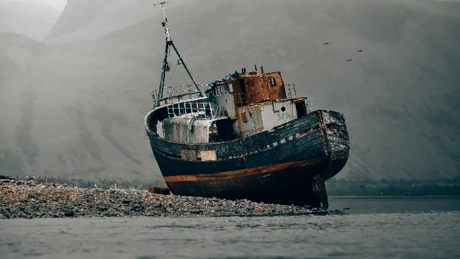 Poor quality background and background of an old barge on the beach