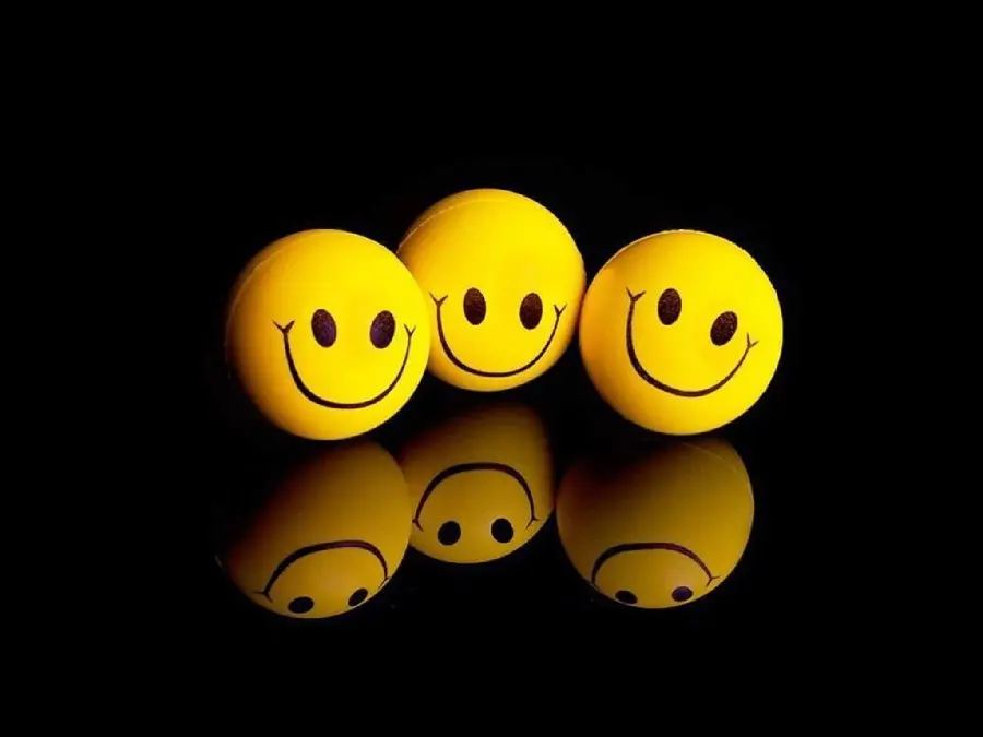 Stock Photo of 3 Smiling Emojis Looking at Their Shadows on a Black Background