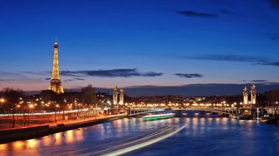 A special attractive tablet background photo of the beautiful view of the river and bridge next to the Eiffel Tower in Paris, France, the cradle of culture at night