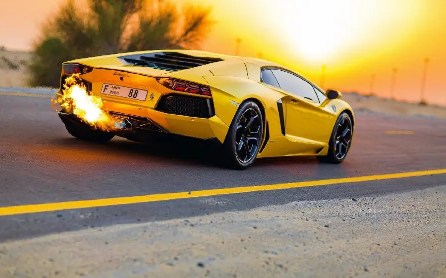 Free download an eye-catching photo of a luxurious yellow Lamborghini with a sunset background