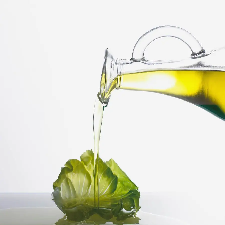 Amazing olive oil pouring picture on lettuce