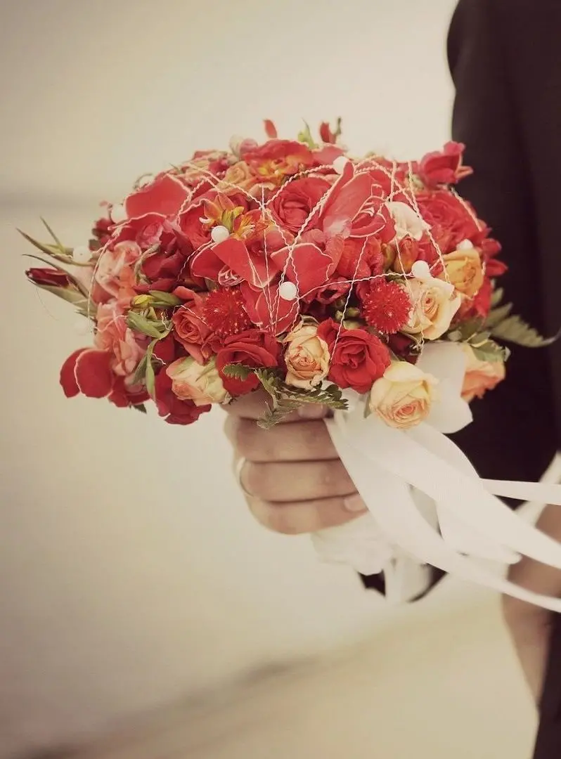 Awesome poster of a bouquet of flowers in the hands of the groom for the bride