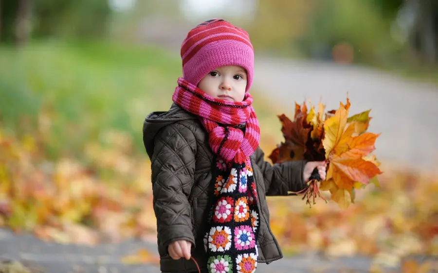 Autumn profile photo of an innocent baby girl with a pink hat and scarf 2022