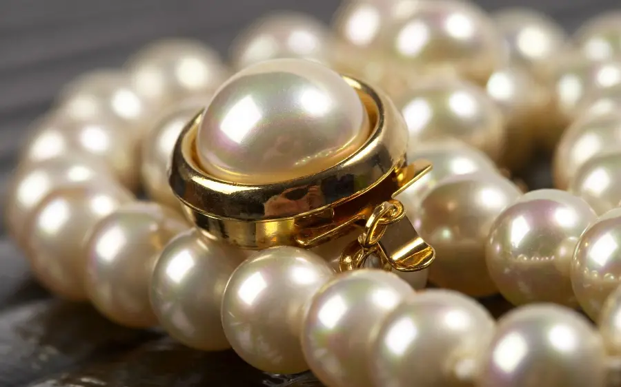 Modern wallpaper of a sparkling half set of pearl rings and necklaces 2022