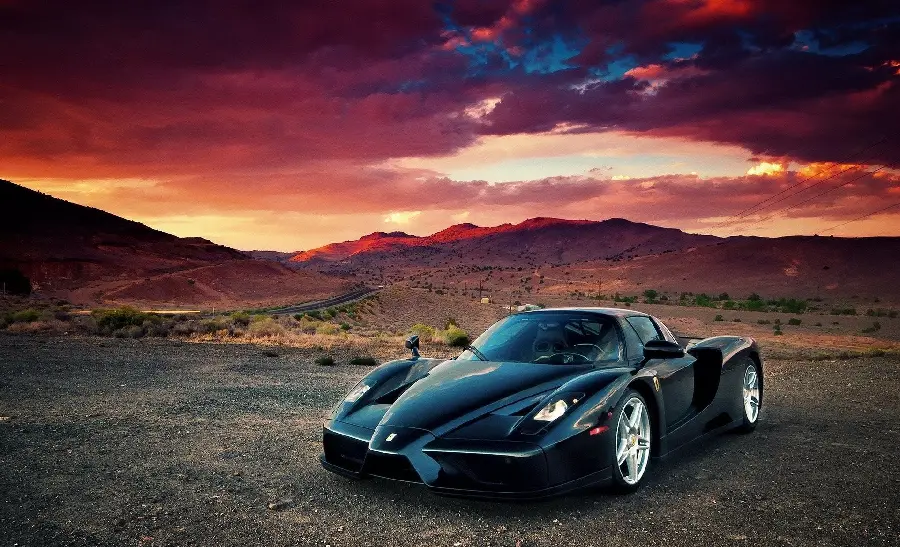 Beautiful background of a black Ferrari Enzo in a desert sunset