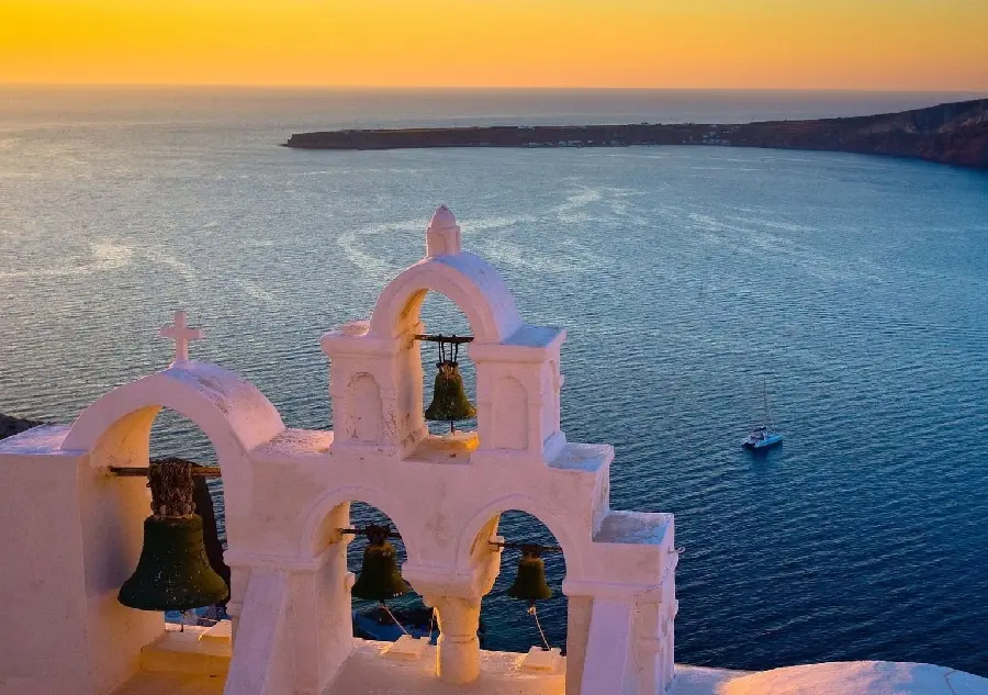 Pure profile shot of the historic bells of Santorini by the roaring sea
