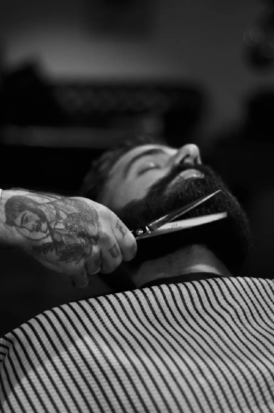 Interesting picture of a barber shaving a beard With a cool black and white theme 