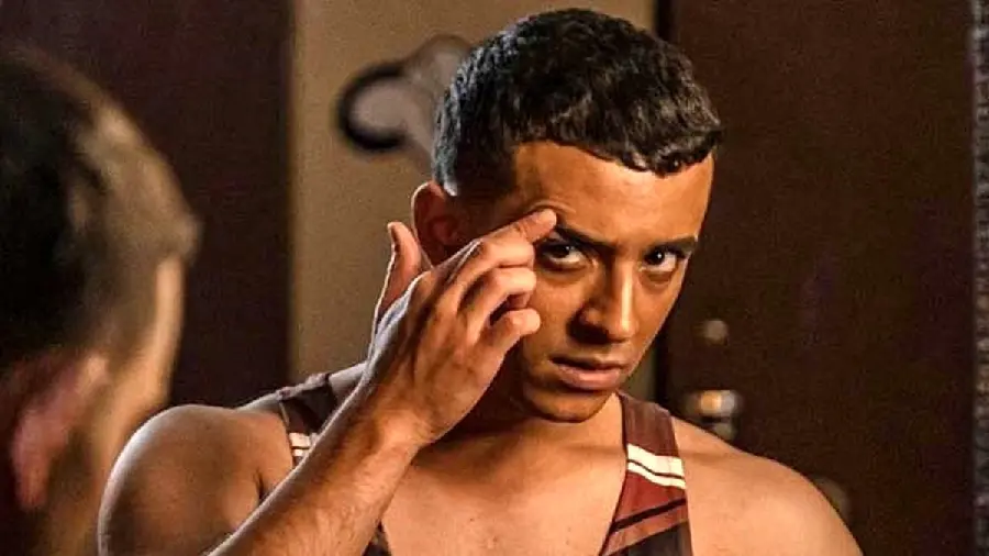 Background Javid in Yaghi looking at the mirror with his finger on his eyebrow
