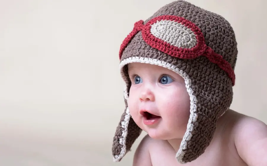 Popular background of a beautiful and naughty little boy with a warm hat