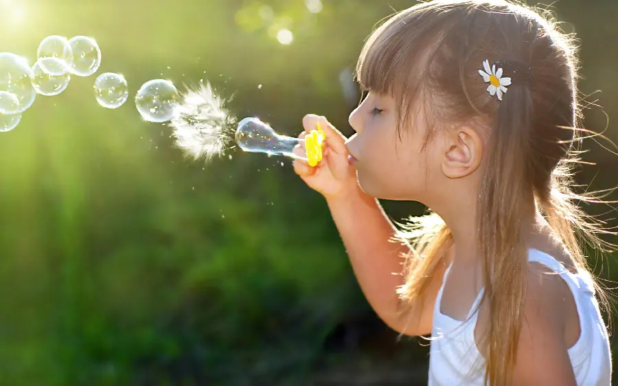 A spectacular photo of a child playing with bubbles for a profile 