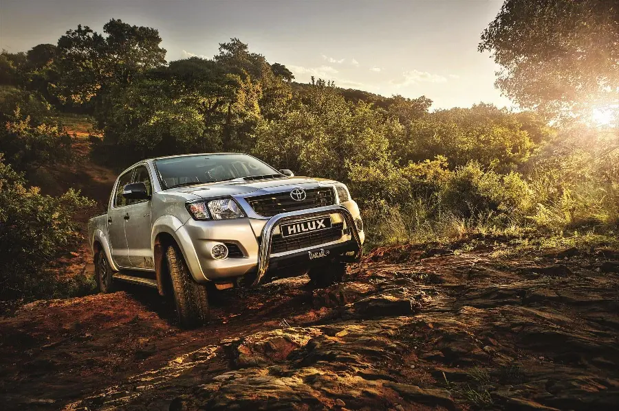 Fantasy and pleasant photo with a silver Toyota Hilux in the forest with sunlight