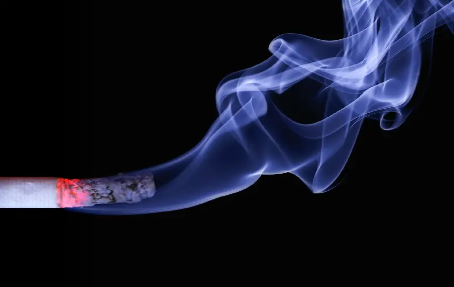 Amazing and blue background of a laptop lit by cigarette smoke