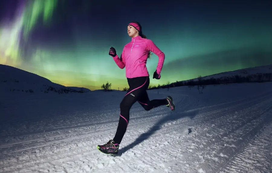 Awesome wallpaper of a woman running in the snow under a starry sky