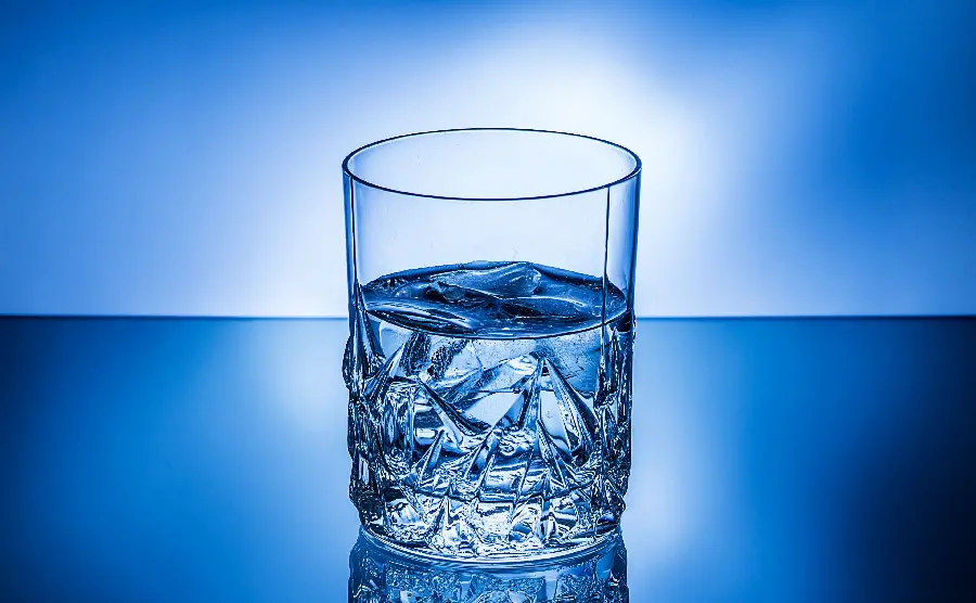 Background of Azure blue from a raised glass of drinking water with a white halo