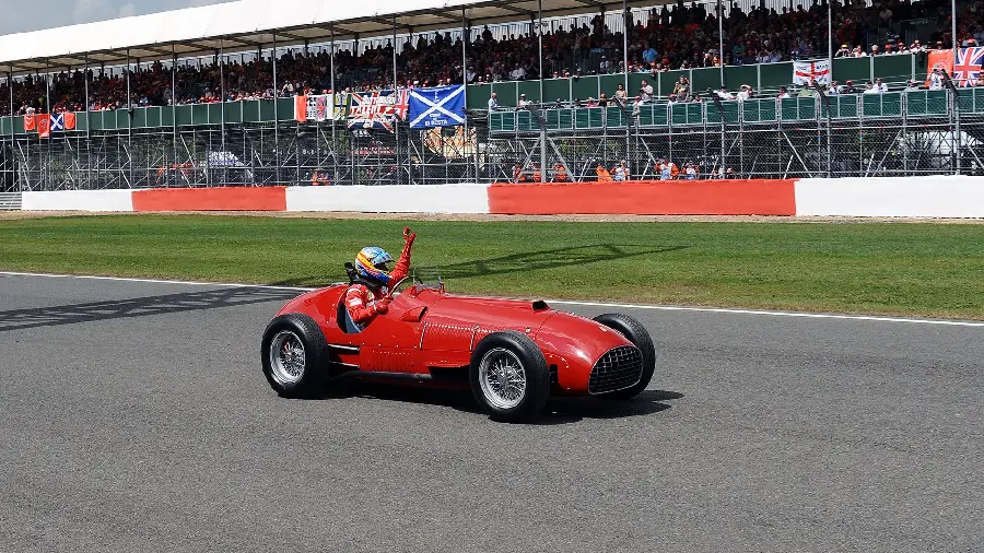 High quality stock image of an old and classic Ferrari and its driver in a rally race