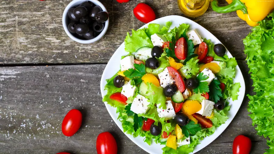 The most amazing wallpaper of a white plate of delicious salad with black olives