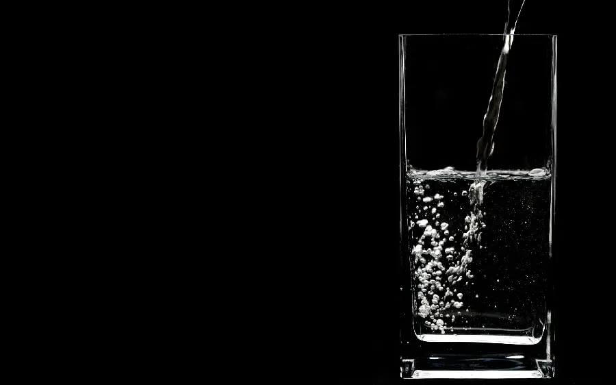 Negative and black background photo of a glass of drinking water