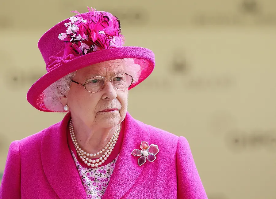Beautiful photo of the Queen of England with glasses and a pink coat 
