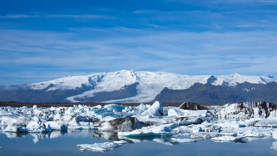 Download beautiful image of ocean covered in white snow and white mountains in front of it in top quality