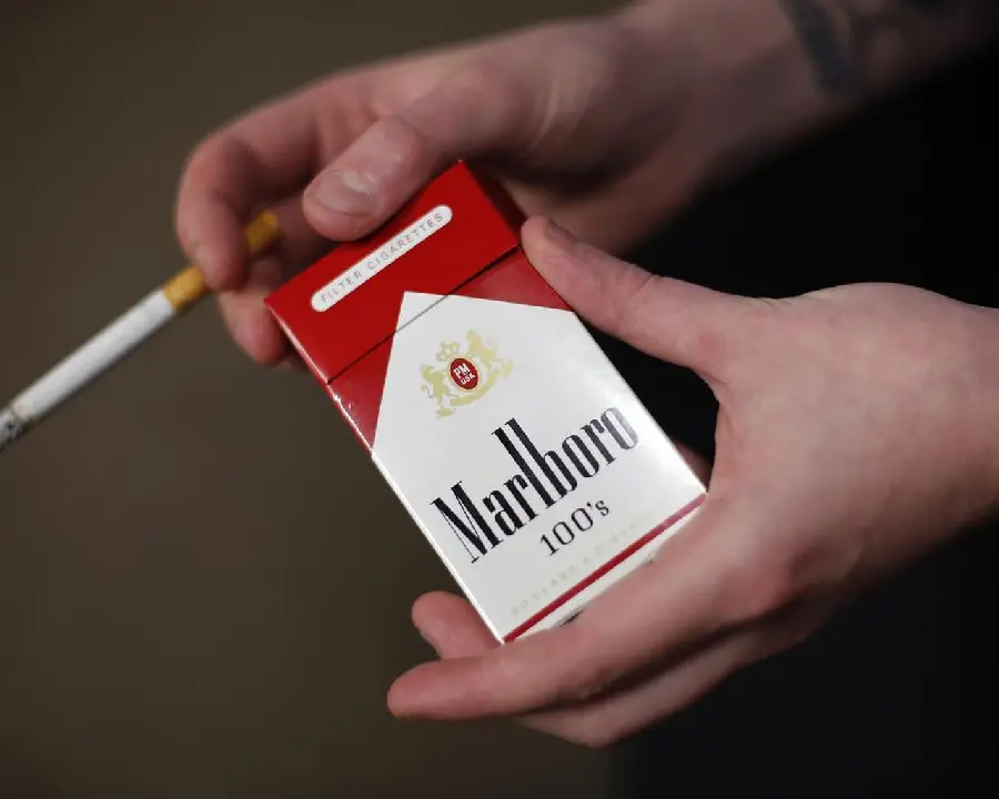 Natural stock photo of a Marlboro cigarette box in two hands with a string between the fingers