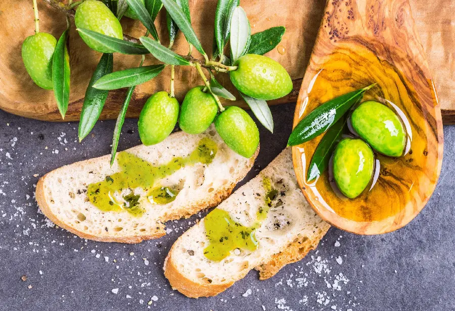 Very beautiful background of two slices of toast dipped in olive oil and bunch of green olives Olives