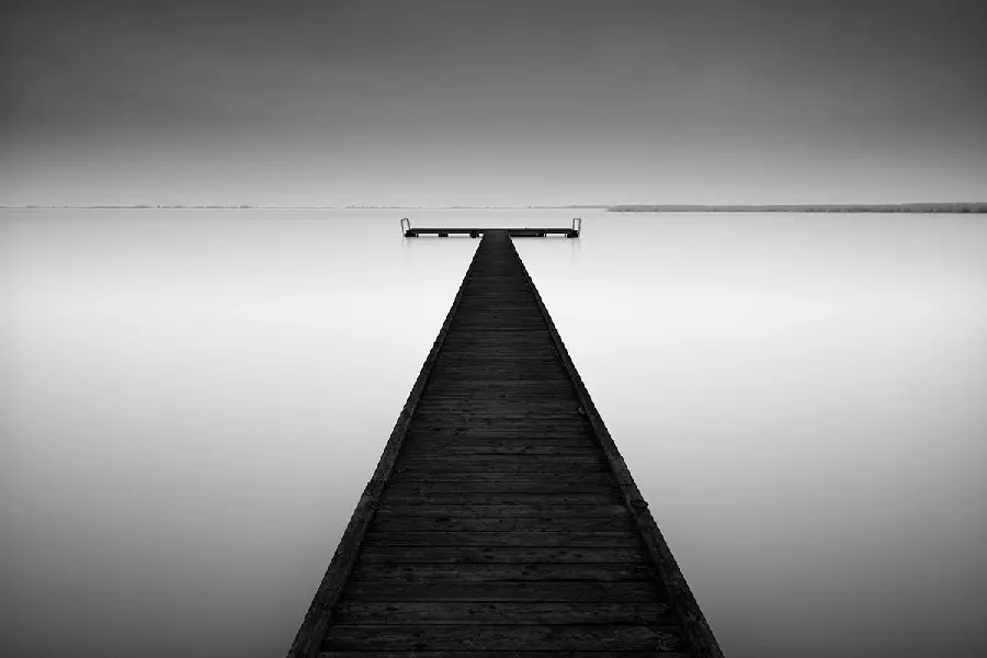 Download a black and white wallpaper of a special wooden bridge on the sea for your desktop 