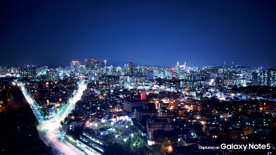 Stock image of glowing streets in a city at night in dark HD quality, suitable for Galaxy phones