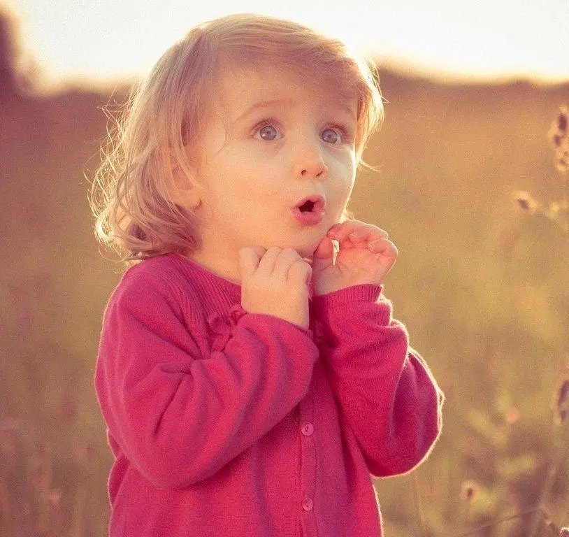 Funny photo of a surprised little girl with golden hair in 4K quality