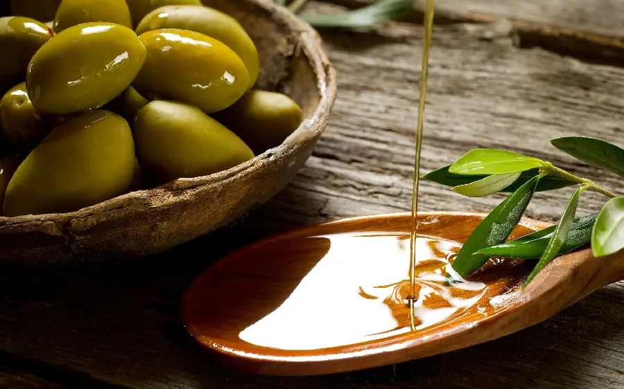 Pleasant background photo of 1 plate of olives with a spoon of first grade olive oil