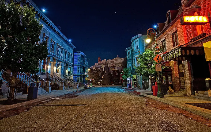 Relaxing picture of beautiful, new, hotel and resort buildings on both sides of a quiet street at night