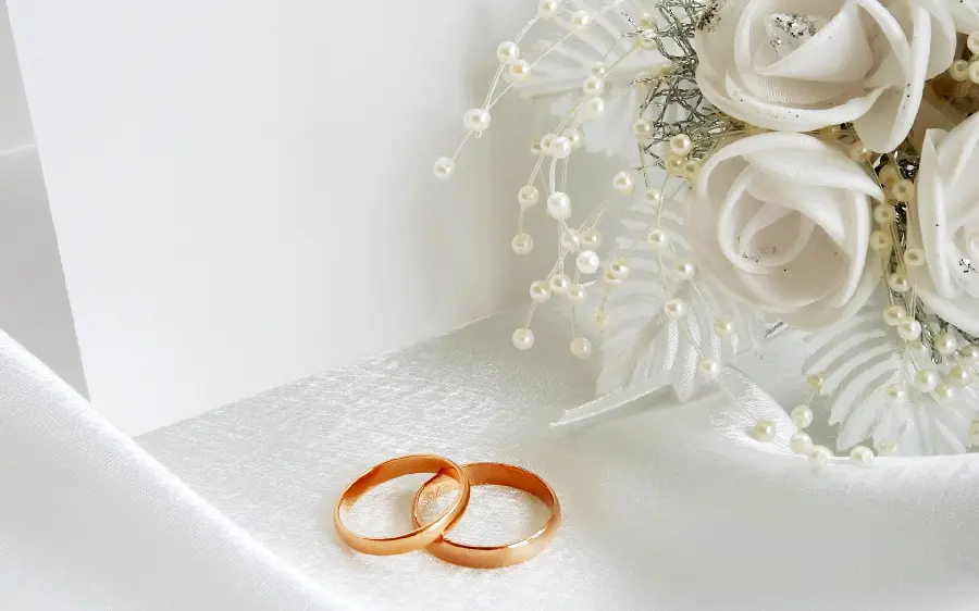Beautiful background of white bouquet of bride and wedding rings
