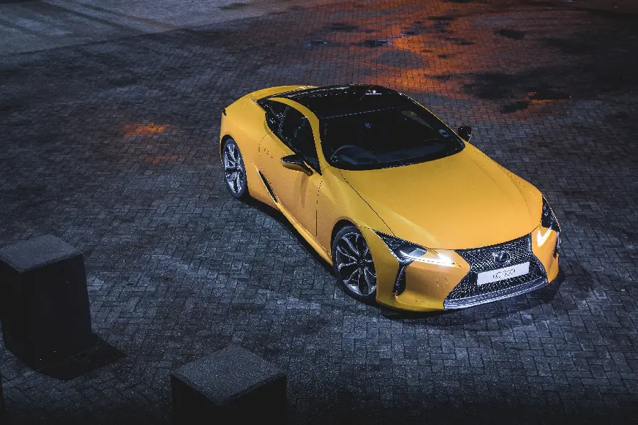 Lively background of yellow Lexus LC 500 on black brick road