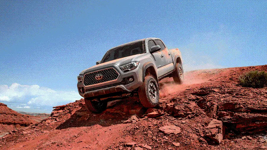 Download a creative fantasy image of an advanced Toyota Tacoma on a hill with red soil