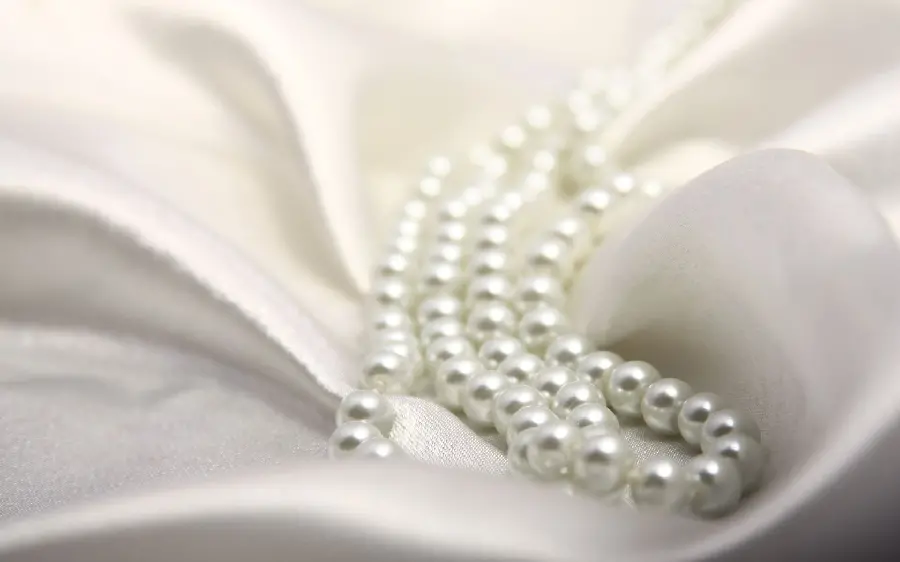 Wallpaper of a Yaba from a pearl necklace in the middle of a white lining