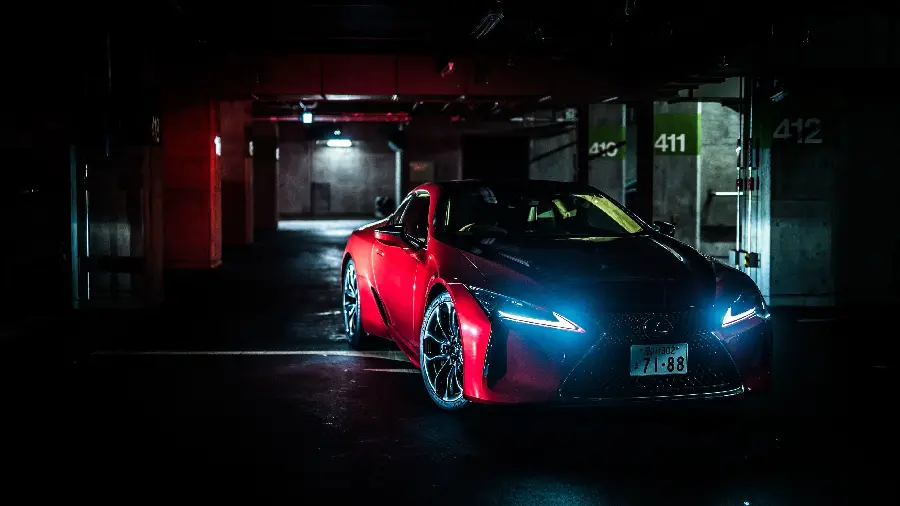 Download a dark background photo of a Lexus LC 500 leaving the parking lot at night