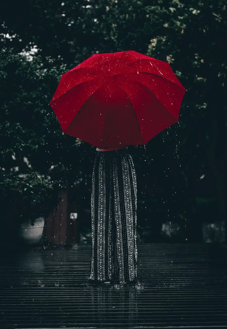 Download fantasy poster of a girl with a red umbrella in real rain and next to a big tree