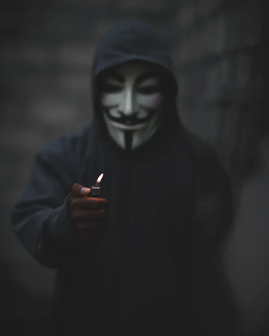Super strange image of a masked man smoking with a lighter in a dark theme 