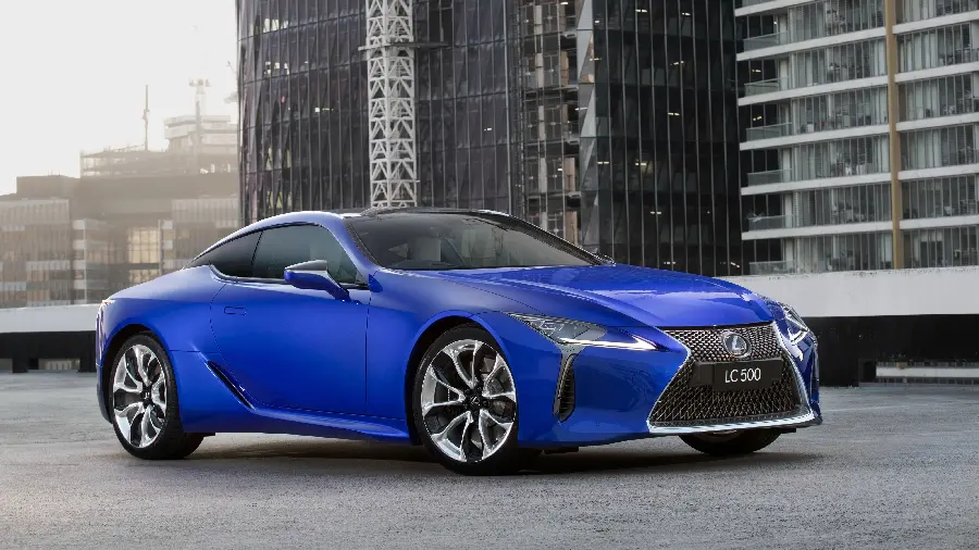 Popular background image of a pale blue Lexus LC 500 in front of several buildings
