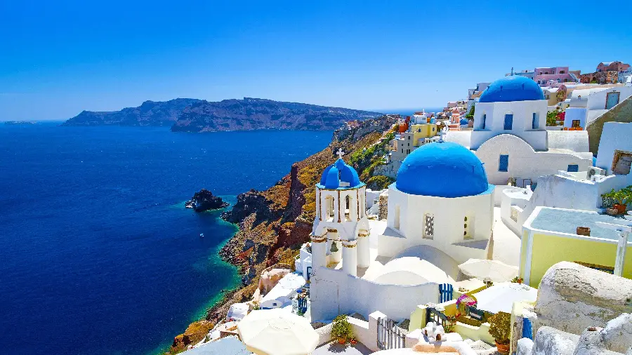 High quality FUII HD photo with lots of sunlight of dome buildings and tourism in Santorini
