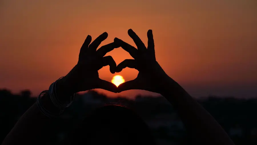 Love Image Making a heart with hands at sunset with a dark theme in Full HD quality
