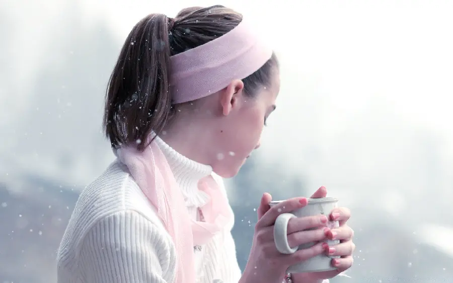 Artistic view of a cute and beautiful girl drinking tea in cold weather