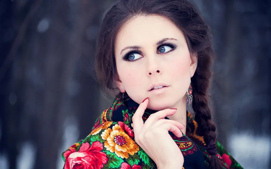 Download a strange tablet-specific image of a surprised girl with blue eyes and black hair and a floral scarf in HD quality