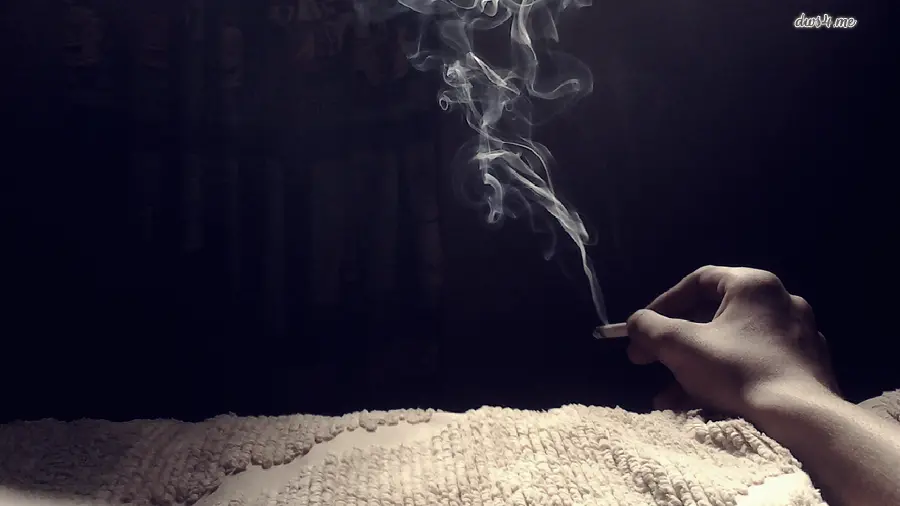 Download dark background photo of white cigarette smoke in hand next to the cigarette