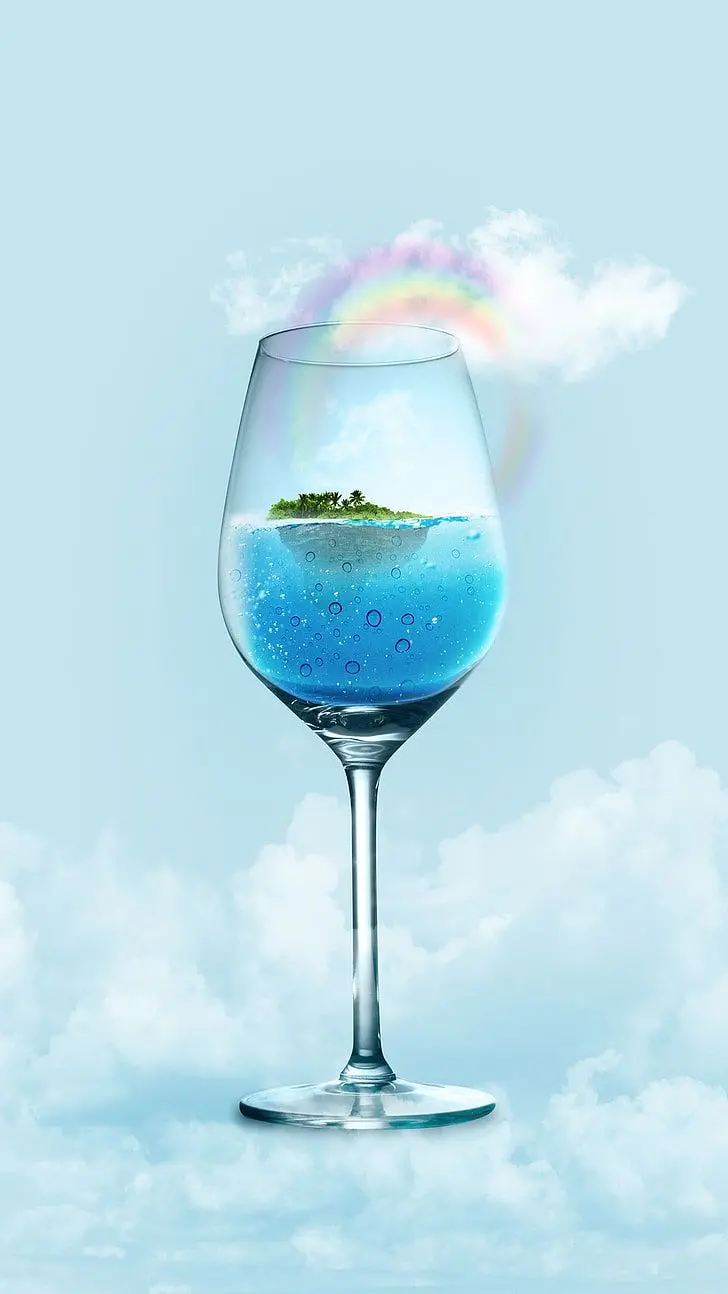Creative poster of a glass of sparkling drinking water, an imaginary island, a cloudy sky and a rainbow